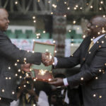 
              Kenya's new president William Ruto, right, seen behind fountain fireworks, shakes hands with outgoing President Uhuru Kenyatta, left, as he is sworn in to office at a ceremony held at Kasarani stadium in Nairobi, Kenya Tuesday, Sept. 13, 2022. William Ruto was sworn in as Kenya's president on Tuesday after narrowly winning the Aug. 9 election and after the Supreme Court last week rejected a challenge to the official results by losing candidate Raila Odinga. (AP Photo/Brian Inganga)
            