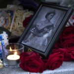 
              A portrait of Queen Elizabeth II, a candle and flowers in remembrance of her Majesty are seen at the Embassy of the United Kingdom in Moscow, Russia, Friday, Sept. 9, 2022. Queen Elizabeth II, Britain's longest-reigning monarch and a rock of stability across much of a turbulent century, died Thursday after 70 years on the throne. She was 96. (AP Photo/Dmitry Serebryakov)
            