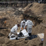 
              Experts work around a body during an exhumation in the recently retaken area of Izium, Ukraine, Friday, Sept. 16, 2022. Ukrainian authorities discovered a mass burial site near the recaptured city of Izium that contained hundreds of graves. It was not clear who was buried in many of the plots or how all of them died, though witnesses and a Ukrainian investigator said some were shot and others were killed by artillery fire, mines or airstrikes. (AP Photo/Evgeniy Maloletka)
            