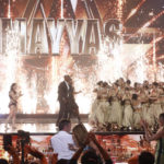 This image released by NBC shows host Terry Crews, center, with members of the female Lebanese dance troupe Mayyas after winning "America's Got Talent," Wednesday, Sept. 14, 2022. Applauding at left is runner-up Kristy Sellars. (Trae Patton/NBC via AP)