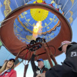 Denise Wiederkehr McDonald, left, prepares for a ride in a hot air balloon as part of a re-enactment of the first Albuquerque International Balloon Fiesta in 1972 during a special event at Coronado Center in Albuquerque, New Mexico, on Friday, Sept. 30, 2022. Wiederkehr's father was among the original 13 pilots to take part in the first fiesta. Wiederkehr McDonald earned her balloon pilot's license at a young age and went on have an aviation career that spanned more than three decades. (AP Photo/Susan Montoya Bryan)