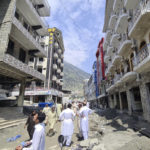 
              Local residents stand near to the damaged buildings destroyed by floodwaters in Kalam Valley in northern Pakistan, Sunday, Sept. 4, 2022. Several countries have flown in supplies, but the Pakistani government has pleaded for even more help, faced with the enormous task of feeding and housing those affected, as well as protecting them from waterborne diseases. (AP Photo/Sherin Zada)
            