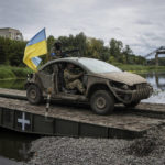
              Ukrainian paratroopers drive on the vehicle with Ukrainian flag on the pontoon bridge across Siverskiy-Donets river in the recently retaken area of Izium, Ukraine, Wednesday, Sept. 14, 2022. (AP Photo/Evgeniy Maloletka)
            