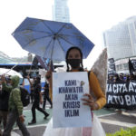
              Environmental activists hold up posters read " we are worried about the climate crisis " during a protest calling for the government to take immediate action against climate change in Jakarta, Indonesia, Friday, Sept. 23, 2022. (AP Photo/Achmad Ibrahim)
            