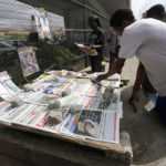 
              People reads newspapers with a front page photo of Britain's Queen Elizabeth II at a newsstand in Obalende Lagos, Nigeria Friday , Sept. 9, 2022. Queen Elizabeth II, Britain's longest-reigning monarch and a rock of stability across much of a turbulent century, died Thursday Sept. 8, 2022, after 70 years on the throne. She was 96. (AP Photo/ Sunday Alamba)
            