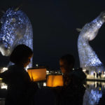 
              Ruby and Sonny Wallace take part in a service of reflection to honor the late Queen Elizabeth II at The Kelpies in Falkirk, Scotland, Sunday, Sept. 18, 2022. (Lesley Martin/PA via AP)
            