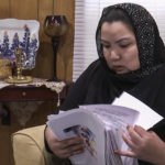 
              FILE - In this image from video, Zumret Dawut, a Uighur from China's western Xinjiang region who forcibly sterilized for having a third child after being released from a Xinjiang detention camp, looks at documents at her home in Woodbridge, Va., on Monday, June 15, 2020. For Dawut and other camp survivors who spoke out, the U.N.'s report on the mass detentions and other rights abuses against Uyghurs and other mostly Muslim ethnic groups in Xinjiang was the culmination of years of advocacy, and a much-welcome acknowledgement of the abuses they say they faced at the hands of the Chinese state. (AP Photo/Nathan Ellgren, File)
            