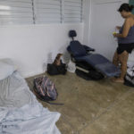 
              A woman and her dog take refuge in a shelter from Hurricane Fiona in Loiza, Puerto Rico, Sunday, Sept. 18, 2022. (AP Photo/Alejandro Granadillo)
            