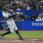 
              New York Yankees' Aaron Judge hits a two-run home run, his 61st homer of the season, during the seventh inning of the team's baseball game against the Toronto Blue Jays on Wednesday, Sept. 28, 2022, in Toronto. (Nathan Denette/The Canadian Press via AP)
            