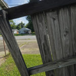 
              A house is seen through the broken fence of a dilapidated storefront property across the street in Alexandria, La., Thursday, Sept. 8, 2022. A female informant on an undercover drug operation entered this house and was raped as her law enforcement handlers left her on her own. The case highlights the perils informants face around the country under loosely regulated arrangements. (AP Photo/Gerald Herbert)
            