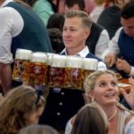 
              A waiter carries beer in one of the beer tents on the opening day of the 187th Oktoberfest beer festival in Munich, Germany, Saturday, Sept. 17, 2022. Oktoberfest is back in Germany after two years of pandemic cancellations, the same bicep-challenging beer mugs, fat-dripping pork knuckles, pretzels the size of dinner plates, men in leather shorts and women in cleavage-baring traditional dresses.  (AP Photo/Michael Probst)
            