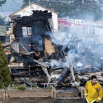 A firefighter passes a home destroyed by the Mill Fire on Saturday, Sept. 3, 2022, in Weed, Calif. (AP Photo/Noah Berger)