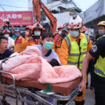 
              In this photo provided by Hualien City Government, a trapped victim is carried on a stretcher as the victim was found and rescued by firefighters from a collapsed building in Yuli township, Hualien County, eastern Taiwan, Sunday, Sept. 18, 2022. A strong earthquake shook much of Taiwan on Sunday, toppling at least one building and trapping two people inside and knocking part of a passenger train off its tracks at a station.(Hualien City Government via AP)
            