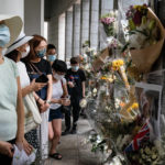 
              People wait in line to pay tribute to Queen Elizabeth II outside the British Consulate in Hong Kong, Friday, Sept. 16, 2022. In Britain, Thousands of mourners waited for hours Thursday in a line that stretched for almost 5 miles (8 kilometers) across London for the chance to spend a few minutes filing past Queen Elizabeth II's coffin while she lies in state. (AP Photo/Anthony Kwan)
            