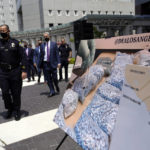 
              FILE - Officials walk past images of illegal drugs outside the Edward R. Roybal Federal Building on May 13, 2021, in Los Angeles. Authorities say a teenage girl died Tuesday night, Sept. 13, 2022, of an apparent overdose at a Los Angeles high school and police are investigating three other possible fentanyl overdoses in the area. (AP Photo/Marcio Jose Sanchez, File)
            
