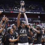 
              Las Vegas Aces' A'ja Wilson holds up the championship trophy as she celebrates with her team their win in the WNBA basketball finals against the Connecticut Sun, Sunday, Sept. 18, 2022, in Uncasville, Conn. (AP Photo/Jessica Hill)
            