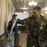 
              A Luhansk People's Republic serviceman votes in a polling station in Luhansk, Luhansk People's Republic, controlled by Russia-backed separatists, eastern Ukraine, Friday, Sept. 23, 2022. Voting began Friday in four Moscow-held regions of Ukraine on referendums to become part of Russia. (AP Photo)
            