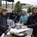 
              People wait in a line to receive humanitarian aid in the recently retaken area of Izium, Ukraine, Wednesday, Sept. 14, 2022. (AP Photo/Evgeniy Maloletka)
            