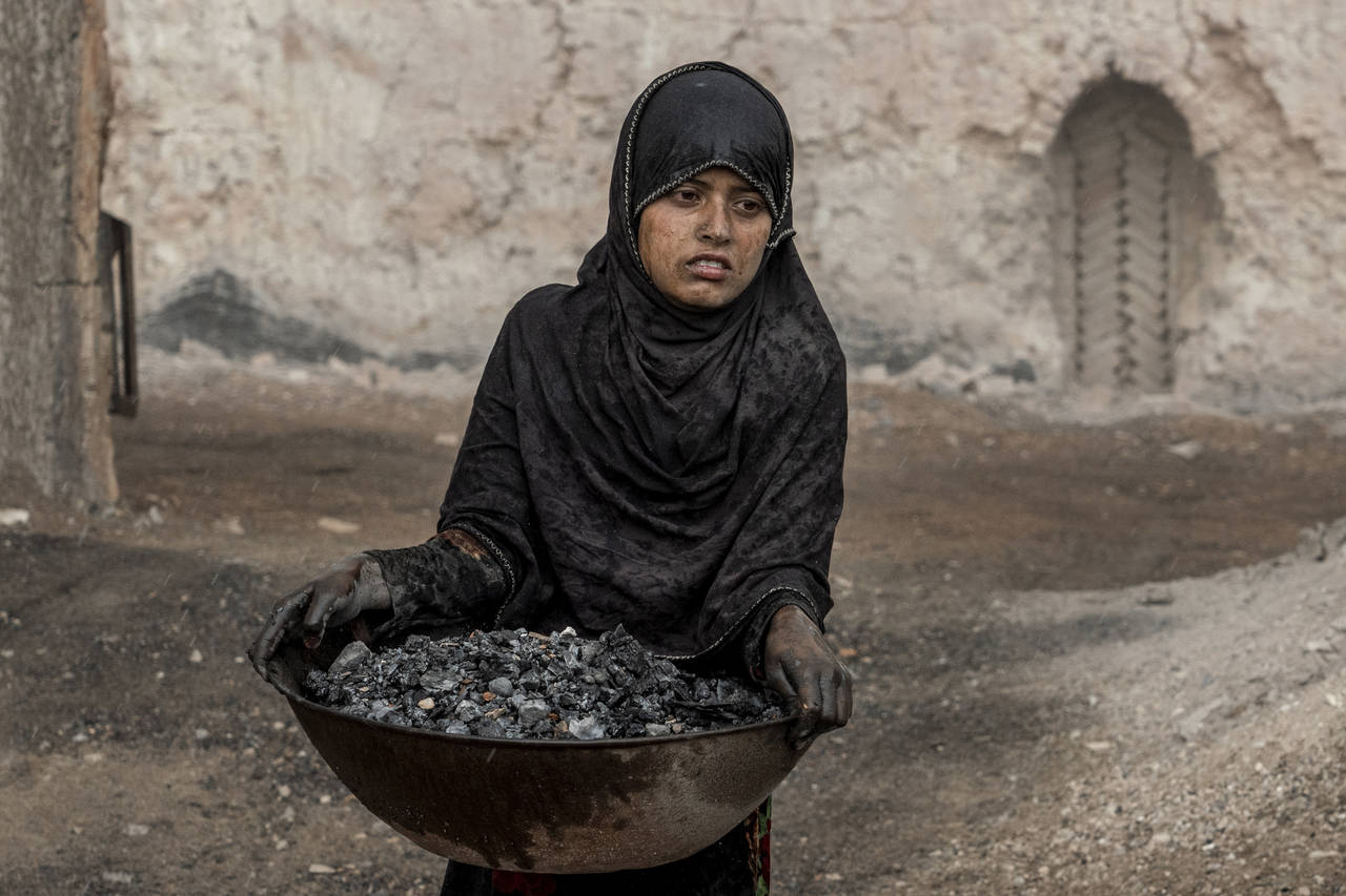 A 9-year-old Afghan girl works in a brick factory on the outskirts of Kabul, Afghanistan, Saturday,...