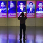 
              A visitor to a museum takes photos of the portraits of Chinese President Xi Jinping and his predecessors in Beijing, Tuesday, Sept. 27, 2022. A former top graft buster at China's ministry for intelligence and counterintelligence has been indicted on bribery charges, just weeks before a major congress of the ruling Communist Party whose leader Xi Jinping has made fighting corruption a signature issue. (AP Photo/Ng Han Guan)
            