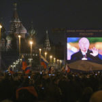 
              People watch on a large screen, as Russian President Vladimir Putin speaks during celebrations marking the incorporation of regions of Ukraine to join Russia, at the Red Square in Moscow, Russia, Friday, Sept. 30, 2022. The signing of the treaties making the four regions part of Russia follows the completion of the Kremlin-orchestrated "referendums." (AP Photo/Dmitry Serebryakov)
            