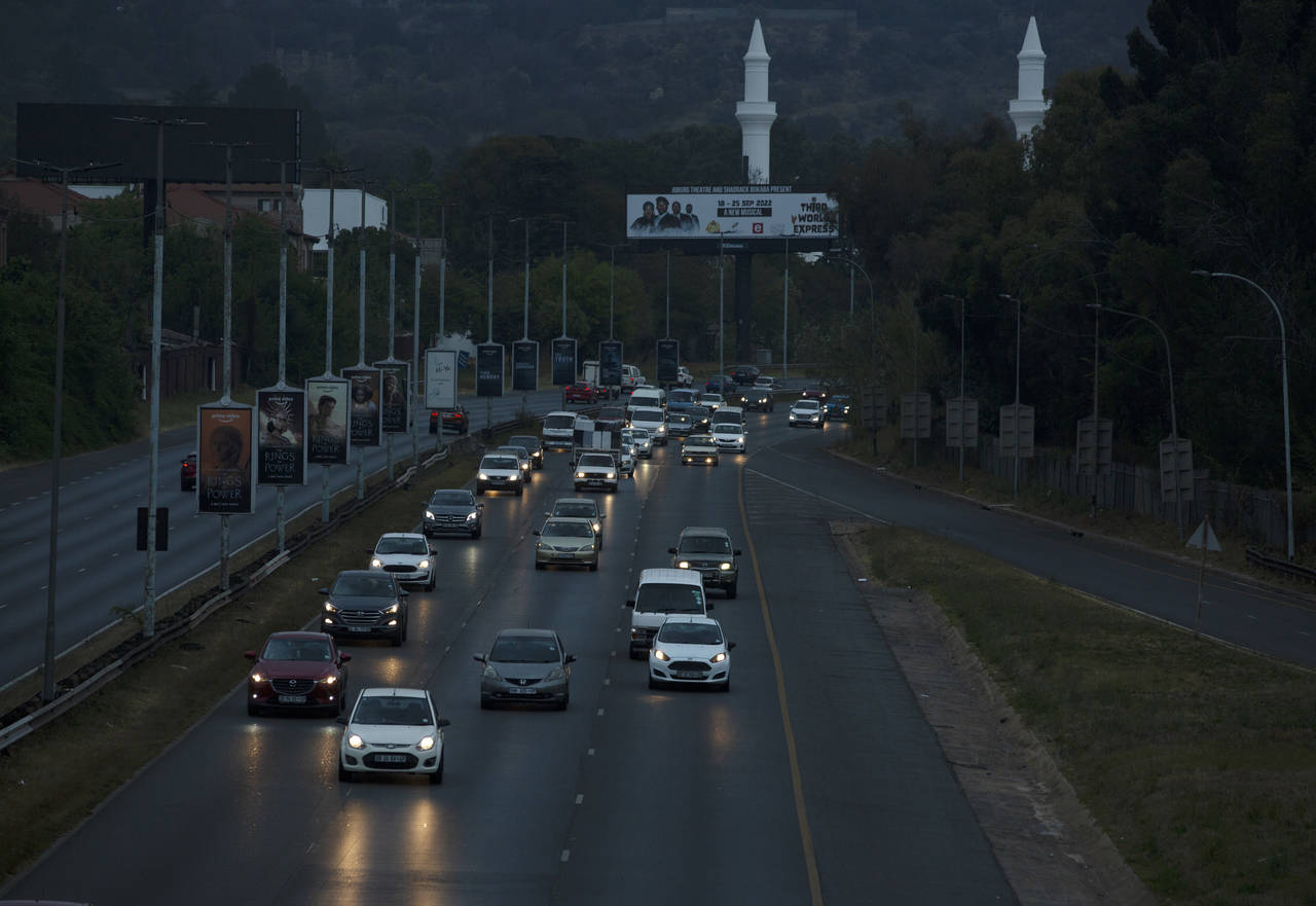 Cars travel on a normally well-lit section of a freeway during a power outage in Johannesburg, Wedn...