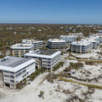 
              Water streams past buildings on the oceanfront after Hurricane Ian passed by the area, Friday, Sept. 30, 2022, in Sanibel Island, Fla. (AP Photo/Steve Helber)
            