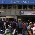
              Media and security gather outside BLOM bank branch where a man who is identified as Abed Soubra is allegedly holding hostages in an effort to get to funds in his account in Beirut, Lebanon, Friday, Sept. 16, 2022. Depositors broke into at least four banks in different parts of crisis-hit Lebanon Friday demanding that they get their trapped savings as chaos spreads in the small Mediterranean nation in the middle of a historic economic meltdown. (AP Photo/Bilal Hussein)
            