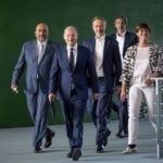 
              Chancellor Olaf Scholz (SPD, 2nd from left), arrives alongside Omid Nouripour (l), federal chairman of the Green Party , Saskia Esken (r), federal chairman of the SPD, and Christian Lindner, center, federal chairman of the FDP and federal minister of finance, followed by government spokesman Steffen Hebestreit (SPD) at the press conference following the deliberations of the SPD, Greens and FDP in the coalition committee in Berlin, Germany, Sunday, Sept. 4, 2022. The coalition committee of the traffic light alliance has decided on a new relief package for citizens. (Michael Kappeler/dpa via AP)
            