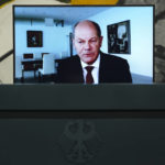 
              German Chancellor Olaf Scholz displayed on a screen during a news conference about the German energy supply with Economy and Climate Minister Robert Habeck and Finance Minister Christian Lindner at the chancellery in Berlin, Germany, Thursday, Sept. 29, 2022. Scholz appears via videolink as he is in quarantine for coronavirus. (AP Photo/Markus Schreiber)
            