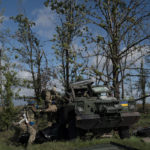 
              Ukrainian national guard servicemen remove the body of a Ukrainian soldier from an armored vehicle in an area near the border with Russia, in Kharkiv region, Ukraine, Monday, Sept. 19, 2022. In this operation seven bodies of Ukrainian soldiers were recovered from what was the battlefield in recent months. (AP Photo/Leo Correa)
            