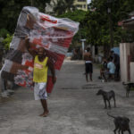 
              A resident of El Fanguito neighborhood carries a mattress in preparation for the arrival of Hurricane Ian, in Havana, Cuba, Monday, Sept. 26, 2022. Hurricane Ian is growing stronger as it approached the western tip of Cuba on a track to hit the west coast of Florida as a major hurricane as early as Wednesday. (AP Photo/Ramon Espinosa)
            