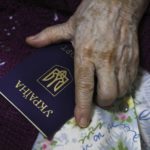 
              An elderly woman from Luhansk region, the territory controlled by a pro-Russia separatist government, but who lives in Russia, holds her Ukrainian passport as she prepares to vote at temporary accommodation facility in Volgograd, Russia, Friday, Sept. 23, 2022. Voting began Friday in four Moscow-held regions of Ukraine on referendums to become part of Russia. Polls also opened in Russia, where refugees from regions under Russian control can cast their votes. (AP Photo)
            