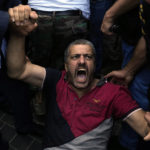 
              A retired army member lies on the ground and chants slogans as others try to enter to the parliament building while the legislature was in session discussing the 2022 budget in downtown Beirut, Lebanon, Monday, Sept. 26, 2022. The protesters demanded an increase in their monthly retirement pay, decimated during the economic meltdown. (AP Photo/Bilal Hussein)
            