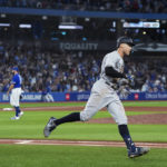 
              New York Yankees' Aaron Judge runs the bases after hitting his 61st home run of the season, off Toronto Blue Jays relief pitcher Tim Mayza, left, during the seventh inning of a baseball game Wednesday, Sept. 28, 2022, in Toronto. (Nathan Denette/The Canadian Press via AP)
            