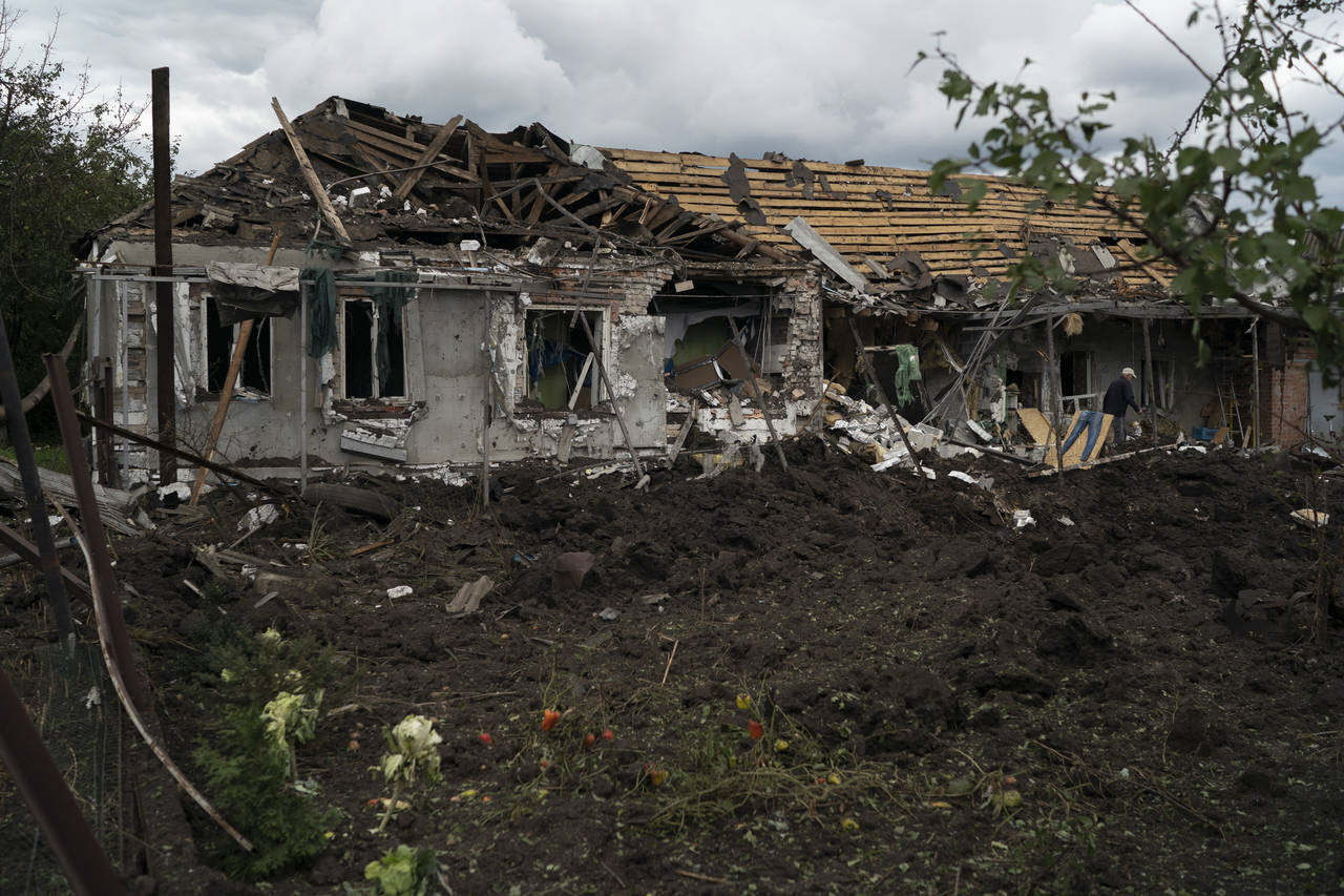 A man walks over the debris of a house that was heavily damaged after a Russian attack in Sloviansk...