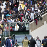 
              Outgoing President Uhuru Kenyatta waves to the people during the sworn in ceremony of new Kenya's President William Ruto, at Kasarani Stadium in Nairobi, Kenya, Tuesday Sept.13, 2022. (AP Photo/Sayyid Abdul Azim)
            