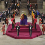 
              The final members of the public pay their respects at the coffin of Queen Elizabeth II, draped in the Royal Standard with the Imperial State Crown and the Sovereign's orb and sceptre, lying in state on the catafalque in Westminster Hall at the Palace of Westminster in London early Monday, Sept. 19, 2022.  (Yui Mok/Pool Photo via AP)
            