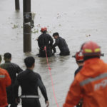 
              South Korean firefighters rescue a citizen near a river in Ulsan, South Korea, Tuesday, Sept. 6, 2022. Thousands of people were forced to evacuate in South Korea as Typhoon Hinnamnor made landfall in the country's southern regions on Tuesday, unleashing fierce rains and winds that destroyed trees and roads, and left more than 20,000 homes without power. (Kim Yong-tai/Yonhap via AP)
            