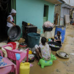 
              Neighbors work to recover their belongings from the flooding caused by Hurricane Fiona in the Los Sotos neighborhood of Higüey, Dominican Republic, Tuesday, Sept. 20, 2022. (AP Photo/Ricardo Hernandez)
            