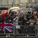 
              People wait for the arrival of the hearse carrying Queen Elizabeth's coffin at Buckingham Palace in London, Tuesday, Sept. 13, 2022. (AP Photo/Markus Schreiber)
            