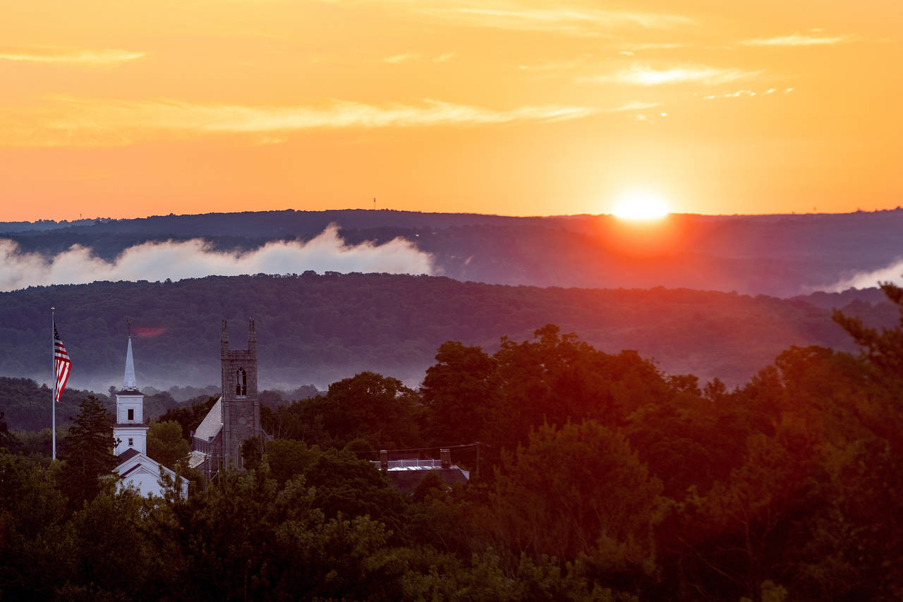 The sun rises over Newtown, Conn., Thursday, Aug. 18, 2022. Now on the cusp of adulthood, the survi...