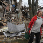 
              Local resident Nina, 72, carries wooden debris near her house, ruined by the Russian shelling a month ago in central Slavyansk, Donetsk region, Ukraine, Saturday, Oct. 29, 2022. She keeps living in this house and collects wooden debris to make an outdoor fire for cooking. (AP Photo/Efrem Lukatsky)
            