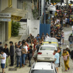 
              Voters line up at a polling station during general elections in Rio de Janeiro, Brazil, Sunday, Oct. 2, 2022. (AP Photo/Matias Delacroix)
            
