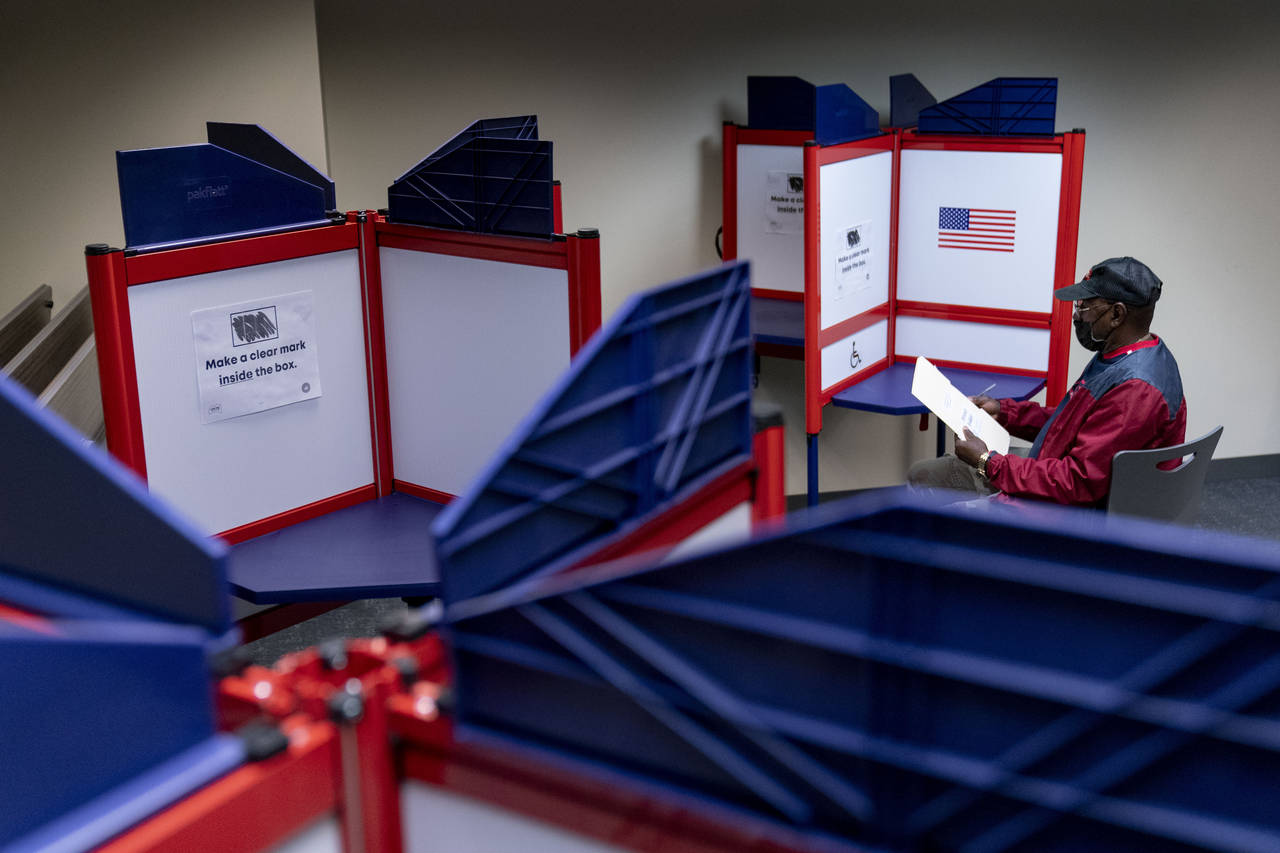 FILE - Cornelius Whiting fills out his ballot at an early voting location in Alexandria, Va., on Se...