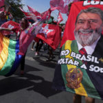 
              A supporter holds a towel emblazoned with an image of Brazil's former President Luiz Inacio Lula da Silva during a campaign event in Brasilia, Brazil, Saturday, Oct. 29, 2022. Da Silva is facing incumbent Jair Bolsonaro in a runoff election set for Oct. 30.  (AP Photo/Eraldo Peres)
            