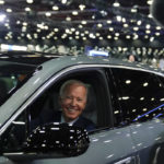 
              FILE - President Joe Biden drives a Cadillac Lyriq through the showroom during a tour at the Detroit Auto Show, Sept. 14, 2022, in Detroit. Biden, a self-described “car guy,'' often promises to lead by example by moving swiftly to convert the sprawling federal fleet to zero-emission electric vehicles. But efforts to help meet his ambitious climate goals by eliminating gas-powered vehicles from the federal fleet have lagged. (AP Photo/Evan Vucci, File)
            