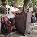 
              Eric Santos uses a suitcase that he keeps all of his possessions in as a table while having a cup of coffee at ShowUp Sac, a nonprofit that provides food, clothing and showers to people experiencing homelessness in Sacramento, Calif., Tuesday, Aug. 9, 2022. Santos, who was recently evicted from his apartment and now sleeps on a park bench, frequents Show Up Sac, for meals and other assistance. Sacramento County had more than 9,200 people experiencing homelessness during this year's annual count, conducted in February. (AP Photo/Rich Pedroncelli)
            