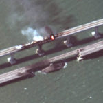 
              This satellite image provided by Maxar Technologies shows damage to the Kerch Bridge, which connects the Crimean Peninsula with Russia crossing a strait between the Black Sea and the Sea of Azov, and rail cars on fire on Saturday, Oct. 8, 2022. (Maxar Technologies via AP)
            