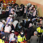 
              Rescue workers treat injured people on the street near the scene in Seoul, South Korea, Sunday, Oct. 30, 2022. South Korean officials say at least 120 people were killed and 100 more were injured as they were crushed by a large crowd pushing forward on a narrow street during Halloween festivities in the capital of Seoul. Choi Seong-beom, chief of Seoul’s Yongsan fire department, said the death toll could rise, saying that an unspecified number among the injured were in critical conditions. (AP Photo/Lee Jin-man)
            
